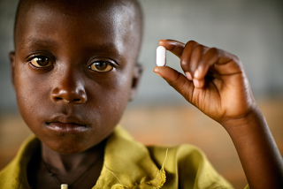 Boy holding a pill